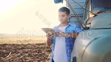 智慧农业。 男子农民司机站在卡车附近的数字平板电脑。 肖像商人农民站在